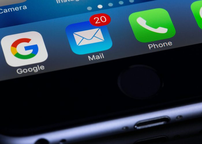 A close-up photo of a smartphone displaying popular apps like Google and Mail.